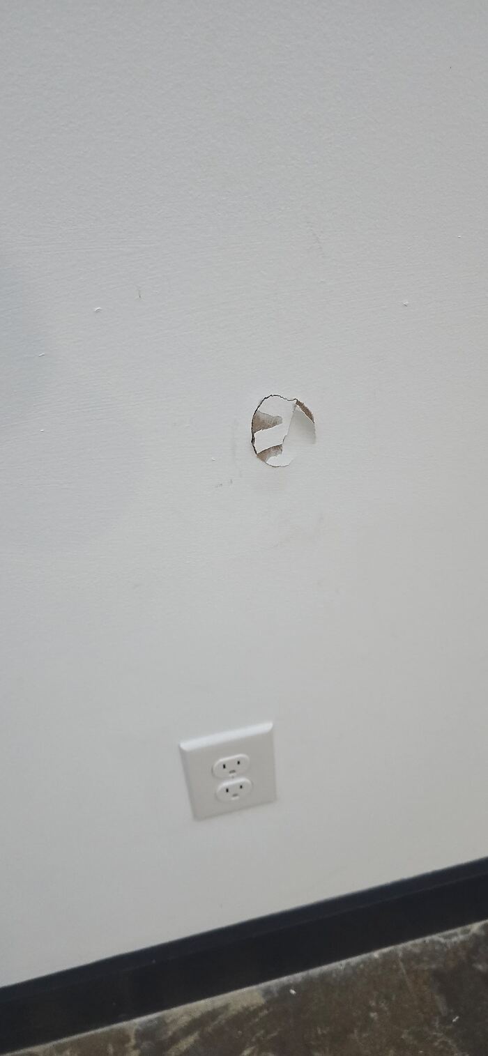 Patched drywall hole next to an outlet, ready for paint